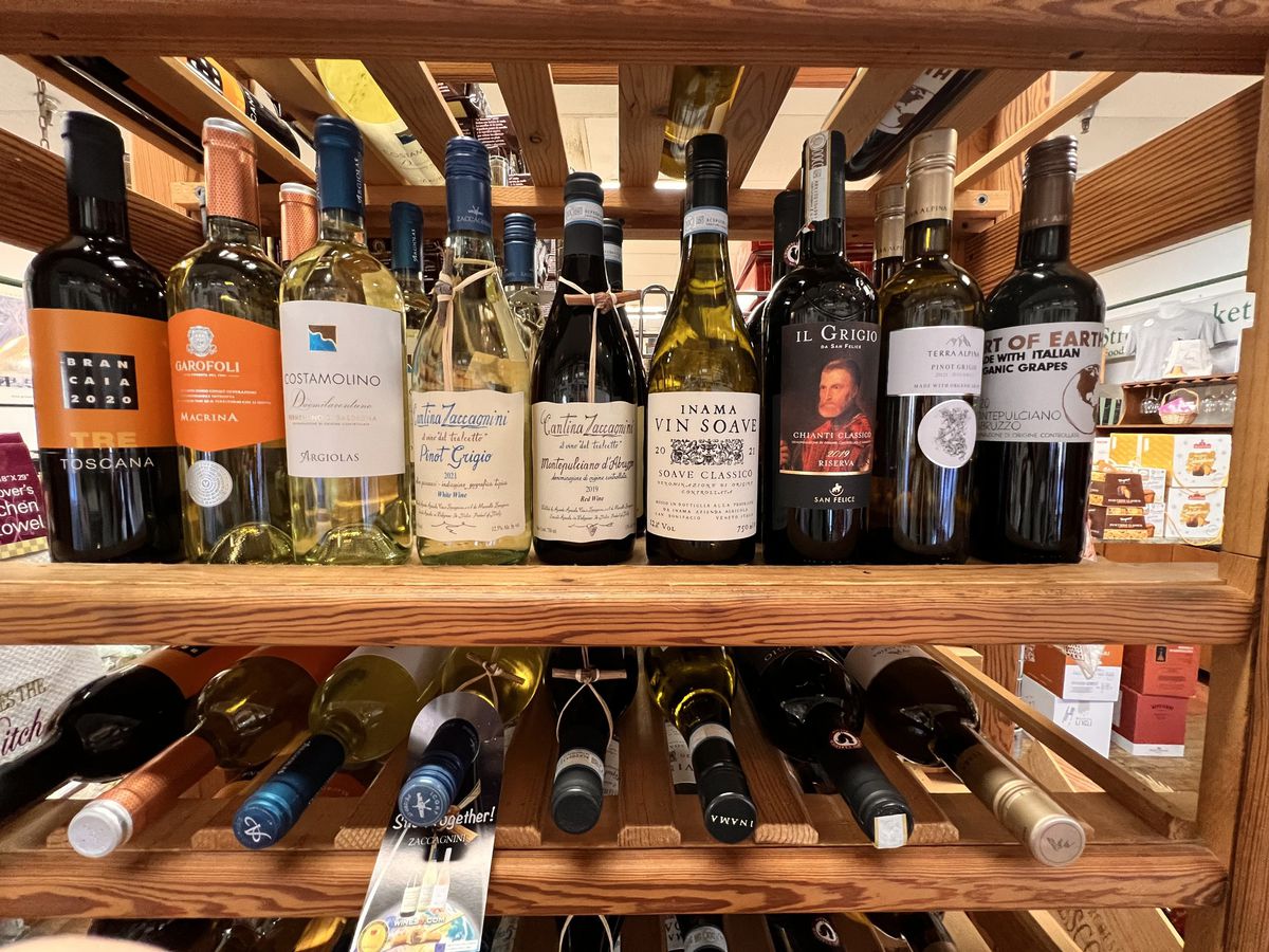 Two wooden shelves lined with mostly Italian wines from E. 48th Street Market in Dunwoody GA. 