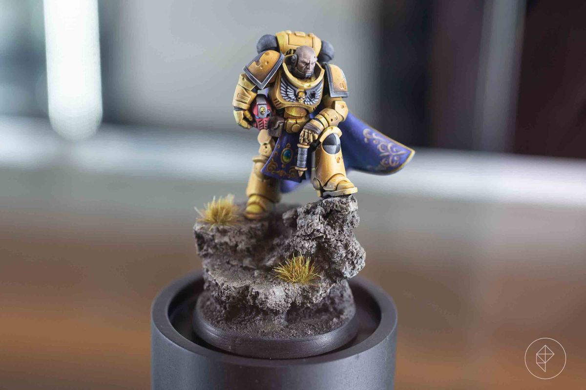 A Space Marine in yellow, his armor marred by battle.