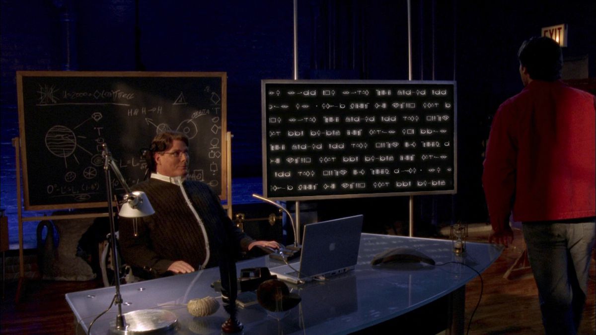 Christopher Reeves as a Smallville character sitting at a desk with a blackboard and a computer screen behind him. The computer screen has a lot of code, and Tom Welling’s Superman is walking up to it.