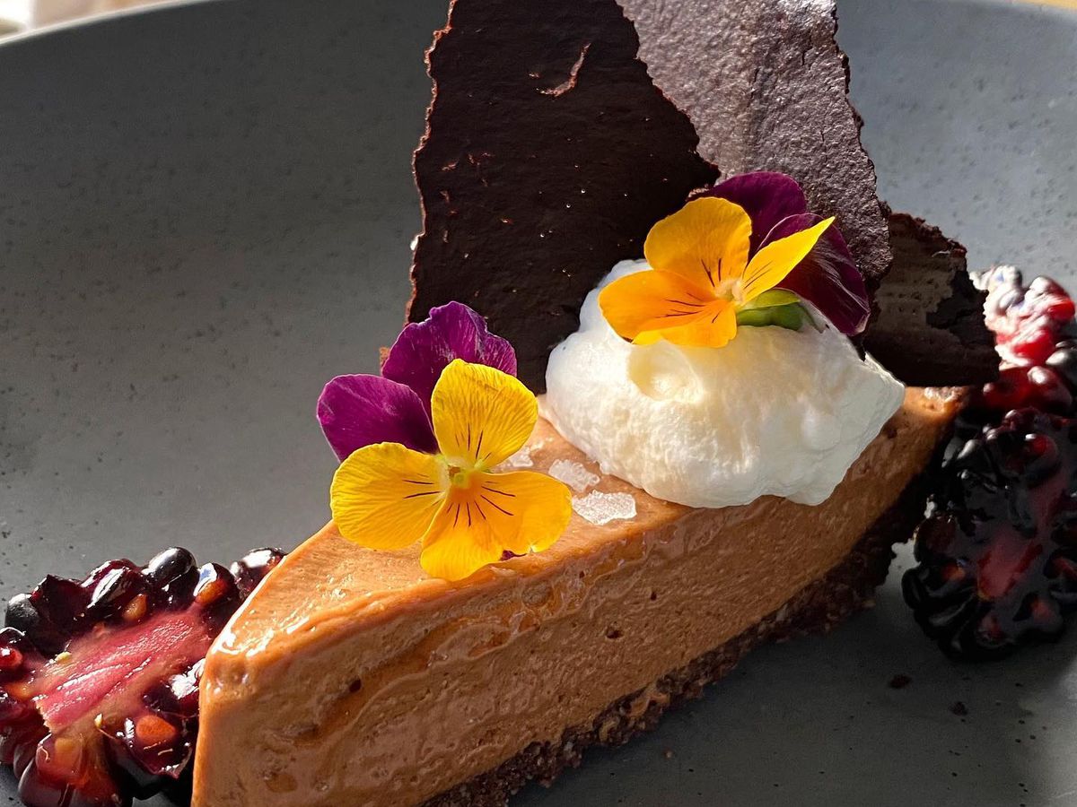 French silk pie made by pastry chef Claudia Martinez at Miller Union in Atlanta garnished with edible purple and yellow flowers and chocolate tuille.