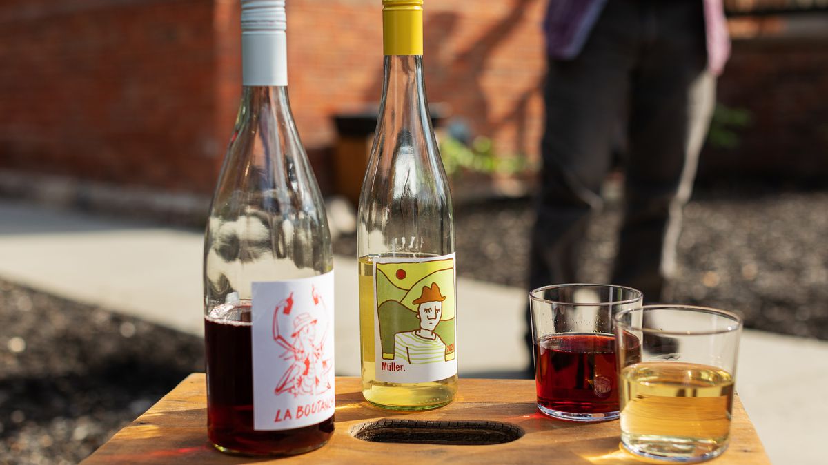 Two bottles of wine and two glasses set on a small wooden table at the outdoor patio Stadt Garten