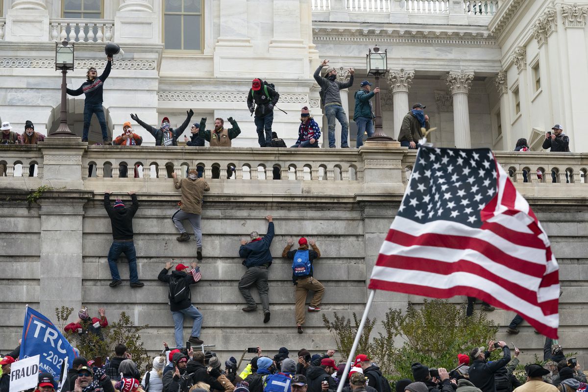 Rioters scale a wall at the U.S. Capitol building on Jan. 6, 2021, in Washington.