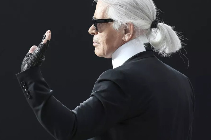 FILE - In this Tuesday, March 5, 2013 filer, Karl Lagerfeld waves after presenting the Chanel’s Fall/Winter 2013-2014 ready to wear collection, in Paris. Chanel’s iconic couturier, Karl Lagerfeld, whose accomplished designs as well as trademark white ponytail, high starched collars and dark enigmatic glasses dominated high fashion for the last 50 years, has died. He was around 85 years old. (AP Photo/Thibault Camus)