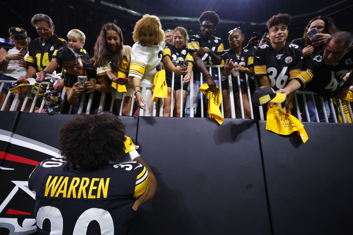 Jaylen Warren #30 of the Pittsburgh Steelers signs autographs for fans following a preseason game against the Atlanta Falcons at Mercedes-Benz Stadium on August 24, 2023 in Atlanta, Georgia.