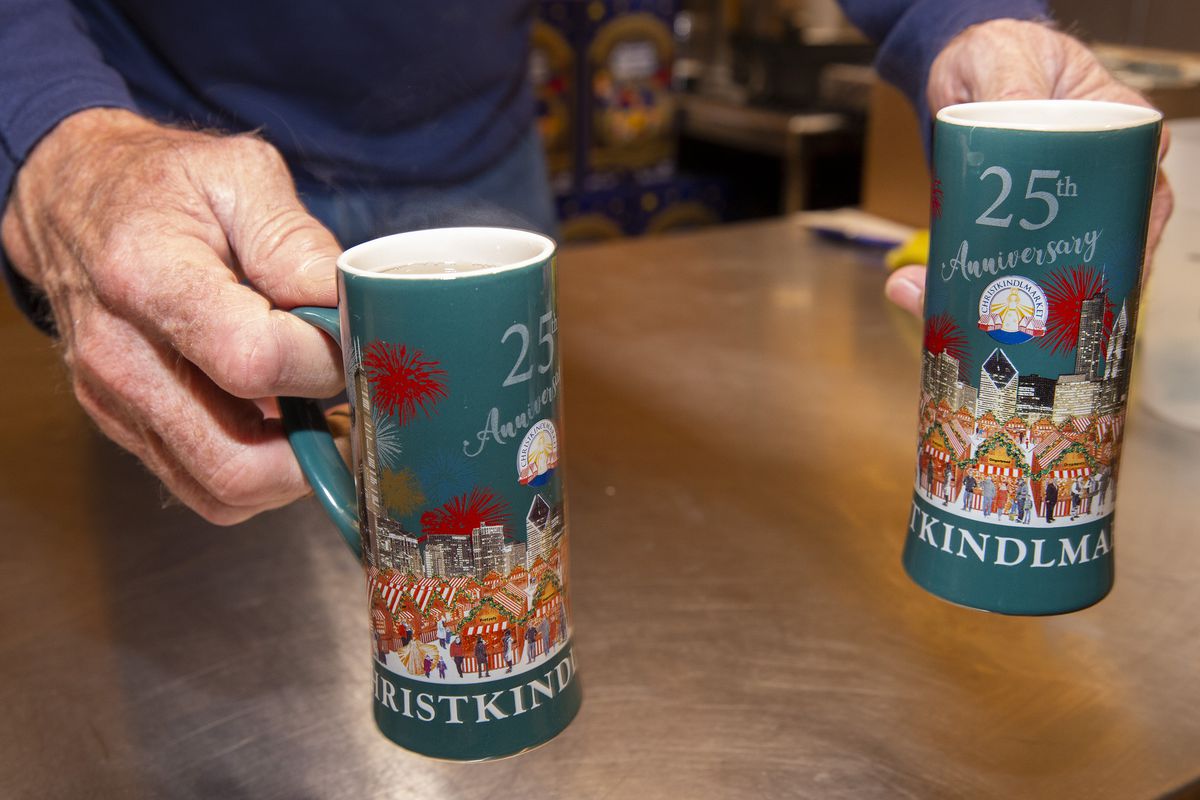 An older person’s hands hold out two blue mugs.