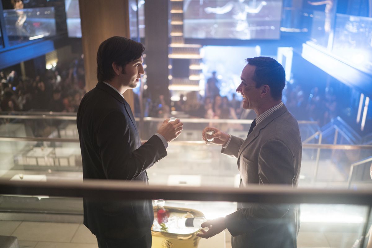Standing in a VIP suite above a crowded club, Greg (Nicholas Braun) and Tom (Matthew Macfadyen) share drinks on Succession