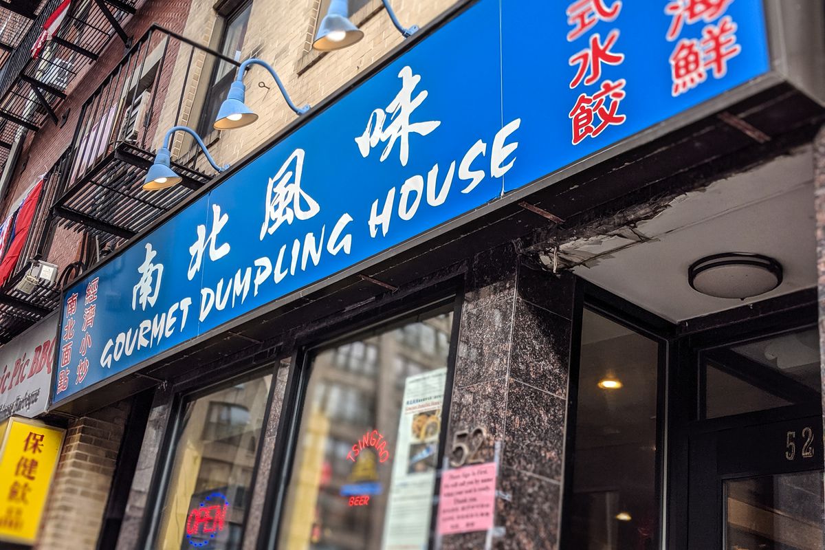 The exterior of Gourmet Dumpling House in Boston’s Chinatown, featuring blue signage with white English text and red Chinese text