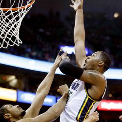 Utah Jazz's power forward Derrick Favors (15) puts up a shot over Spurs' Boris Diaw as the Utah Jazz and the San Antonio Spurs play Saturday, Dec. 14, 2013 at EnergySolutions Arena in Salt Lake City. The Spurs won 100-84.