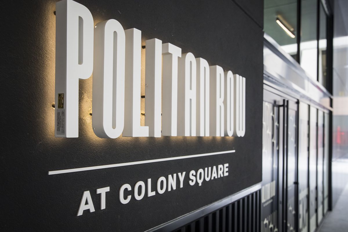 The lit up white, raised-lettered sign reading “Politan Row at Colony Square” set against a shiny black background in Atlanta 