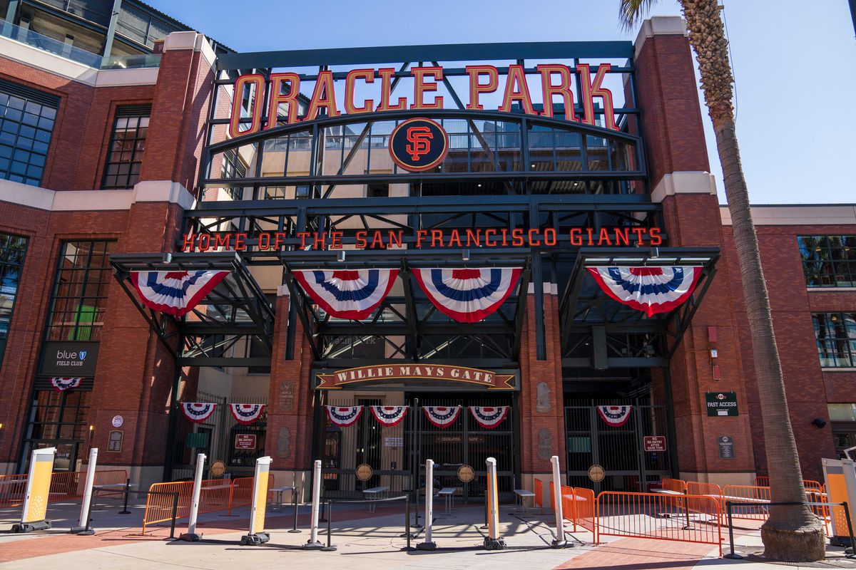 Alt text: The Willie Mays gate of Oracle Park, decorated with celebratory red, white and blue banners for the 2021 National League Division Series between the Giants and Dodgers.