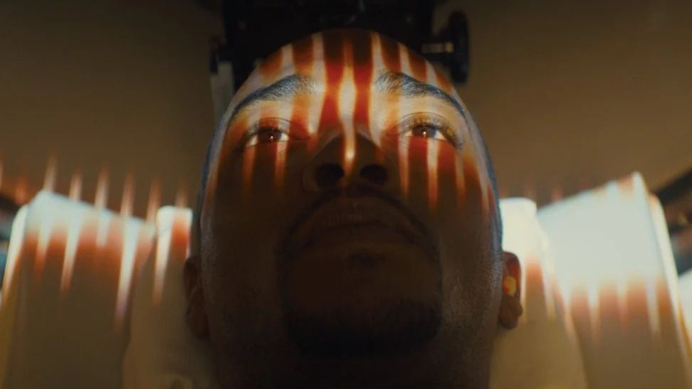 Lights flash across the surface of Anthony Mackie’s face as he lies down for a brain scan.