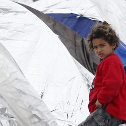 A migrant girl walks in an improvised camp on the border line between Macedonia and Serbia near the northern Macedonian village of Tabanovce, Friday, March 11, 2016. About 1,500 refugees remain stranded at the Macedonian border with Serbia as the borders on the Balkan migrant route are closing.  