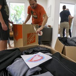 A drawing by Zoe Oyler, not pictured, sits on top of a care package destined for the Bahamas while volunteers help Luke Oyler, not pictured, with his Eagle Scout project at Oyler’s home in Salt Lake City on Sunday, Sept. 22, 2019. Oyler put together 24 care packages consisting of an eight-man tent, air mattresses, sheets, headlamps, handwritten notes and spare batteries to send to the Bahamas, which was devastated by Hurricane Dorian.