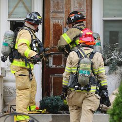 Salt Lake City firefighters break the lock of a home as they battle a fire at 1487 S. Edison in Salt Lake City on Tuesday, Nov. 1, 2016.