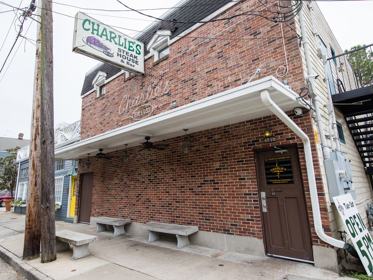 Brick exterior of restaurant with brown door and Charlie’s Steak House sign