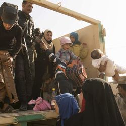 Iraqi soldiers help women and children who have fled fighting in Mosul into trucks to take them to camps in this Saturday, Nov. 12, 2016 photo taken at a checkpoint in Mosul’s Gogjali district, Iraq. Under IS rule in Mosul, many families kept their children out of the schools, which were run by the militants and used to instill their radical ideology. They even purged plus signs from math books because they looked like Christian crosses, residents say. 