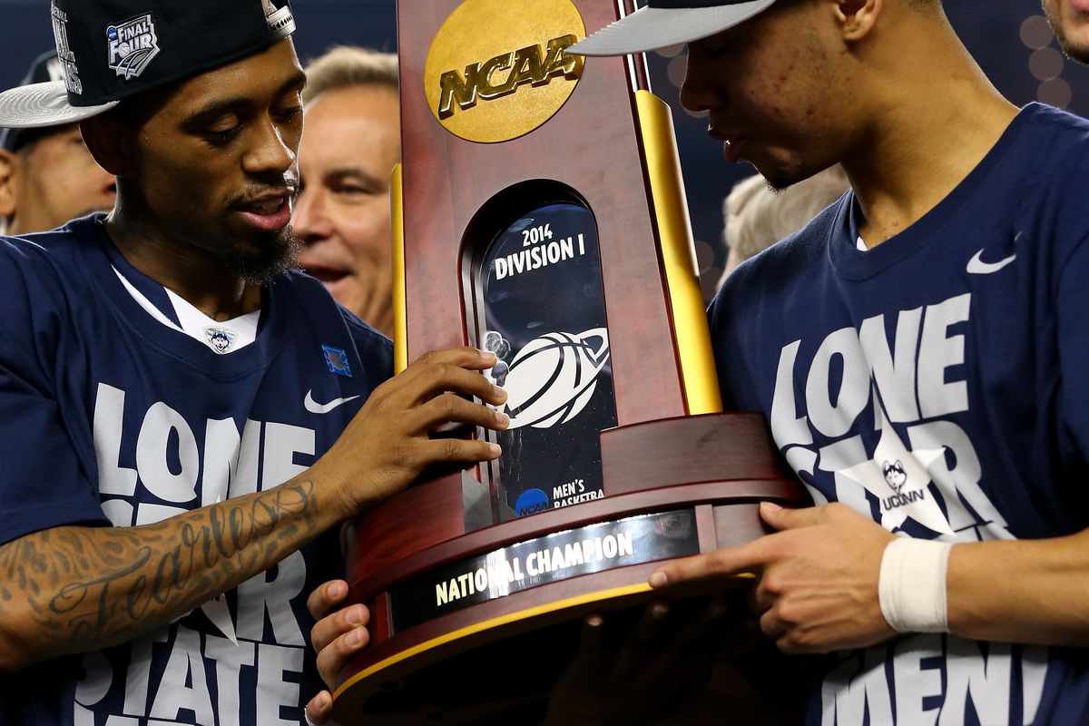 ARLINGTON, TX - APRIL 07: Ryan Boatright #11 and Shabazz Napier #13 of the Connecticut Huskies hold the trophy after defeating the Kentucky Wildcats 60-54 in the NCAA Men's Final Four Championship at AT&T Stadium on April 7, 2014 in Arlington, Texas.