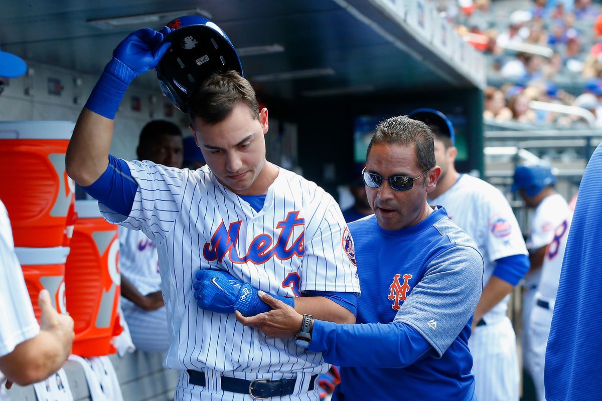 Michael Conforto leaves a game with an injury, helped by a trainer for the Mets