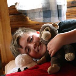 In this August 2013 photo provided by Sanborn Western Camps, a Junior camper holds his stuffed animal “friend” at camp in Florissant, Colo. Overcoming homesickness and spending time away from parents helps children gain self-assurance and independence, experts say.  