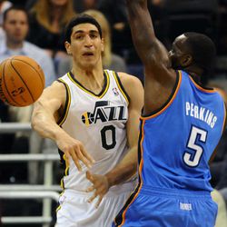 Utah Jazz center Enes Kanter (0) delivers a pass around Oklahoma City Thunder center Kendrick Perkins (5) during a game at Energy Solutions Arena on Wednesday, October 30, 2013.