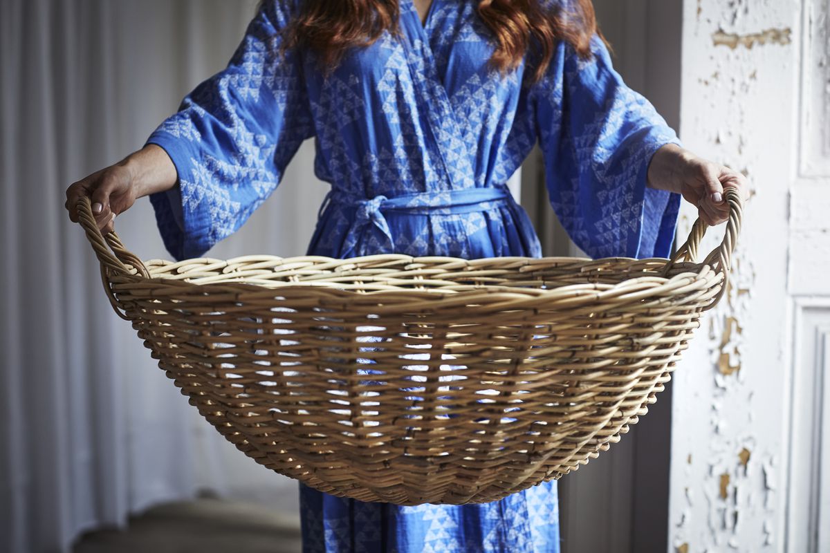 Woman in blue robe holding rattan basket