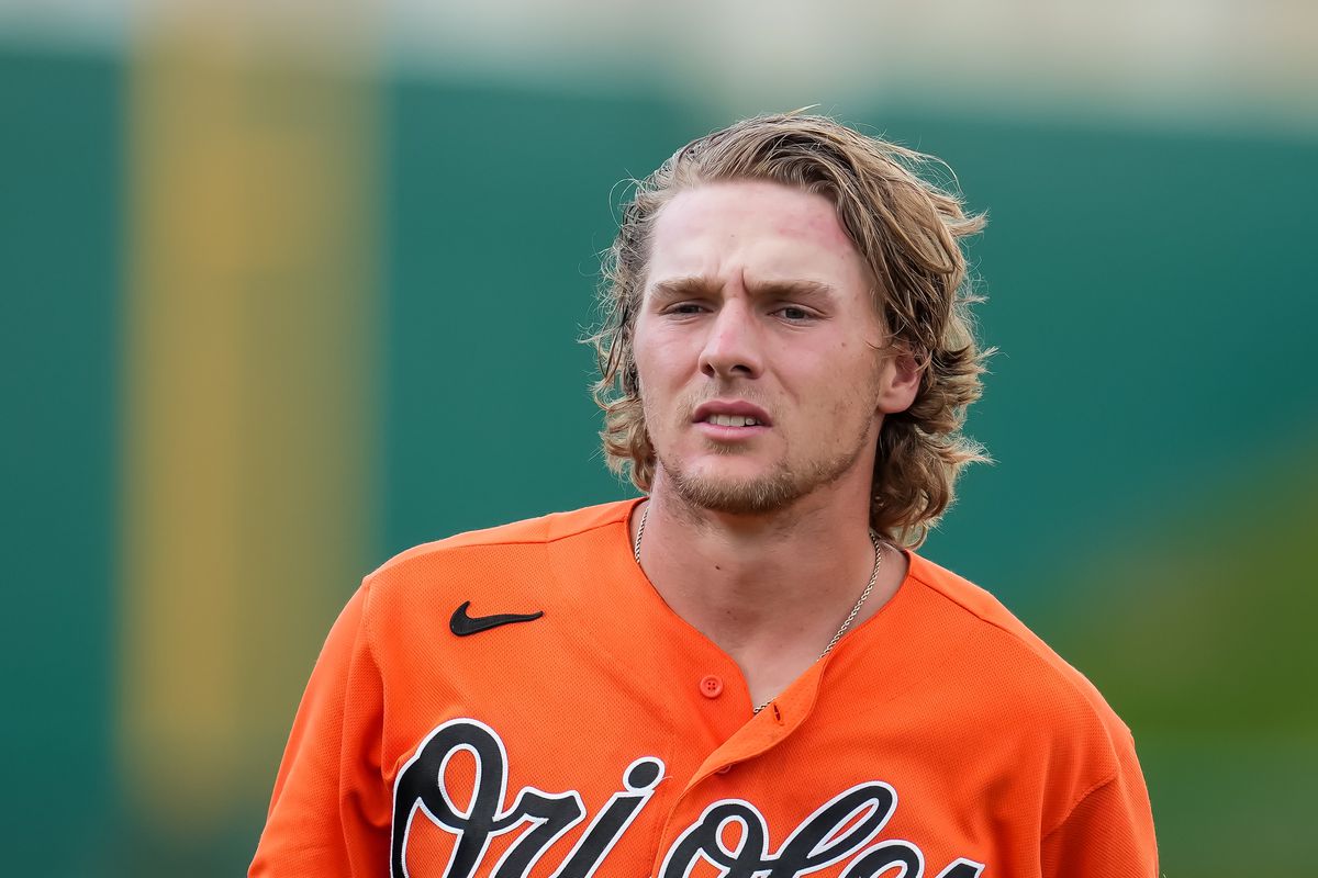 Gunnar Henderson, wearing an orange Orioles jersey, with hair gloriously flowing.