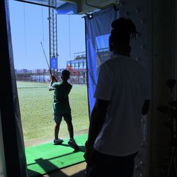 Dre Kirkpatrick watching his son Dre on the driving range in NYC.