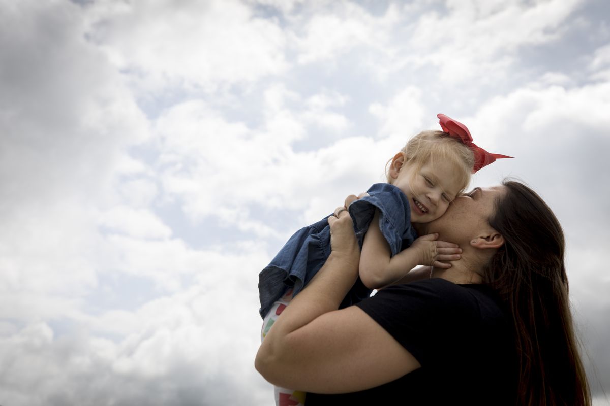 Lindsay Clark kisses her daughter Lily outside their home in Aledo, Texas.