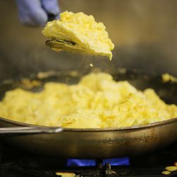 Teen volunteers cook eggs to make breakfast burritos at the Sugarhouse Boys and Girls Club to feed the homeless in Salt Lake City, Utah, on Thursday, July 18, 2019.