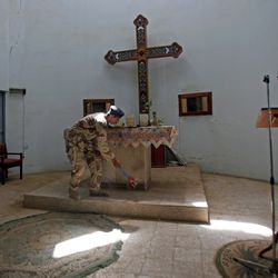 An Iraqi army soldier sweeps inside a Christian church in central Baghdad, Iraq, after two bombs detonated overnight, Sunday, July 12, 2009.