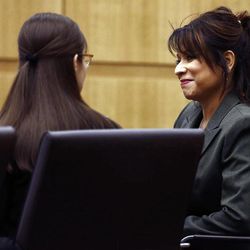 Mitigation specialist Maria DeLaRosa, right, talks to defendant Jodi Arias as defense attorney Kirk Nurmi presents his closing arguments  during her trial Friday, May 3, 2013 at Maricopa County Superior Court in Phoenix.  Arias is charged with first-degree murder in the stabbing and shooting death of Travis Alexander, 30, in his suburban Phoenix home in June 2008. 