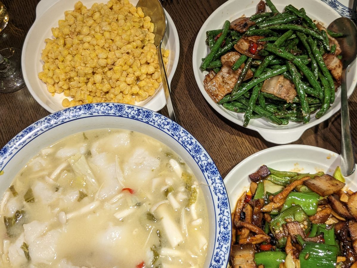 Bowls of soup, corn kernels, green beans, and pork belly.