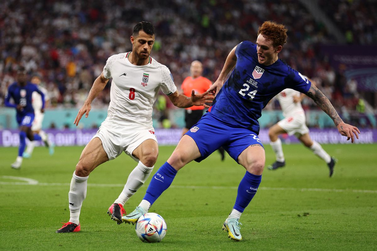 Josh Sargent of USA battles for the ball with Morteza Pouraliganji of Iran during the FIFA World Cup Qatar 2022 Group B match between IR Iran and USA at Al Thumama Stadium on November 29, 2022 in Doha, Qatar.