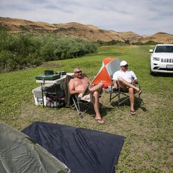 Jeff Wheeler and Ed Lochridge, of Visalia, Calif., hang out at their campsite before watching Monday morning's total solar eclipse at Mann Creek Reservoir, north of Weiser, Idaho on Sunday, Aug. 20, 2017.