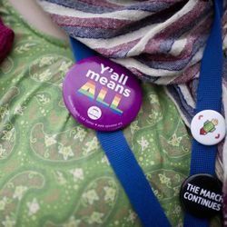 A supporter of same-sex marriage wears a "Y'all means ALL" button at the courthouse before couples are allowed to file for a marriage license, Monday, Feb. 9, 2015, in Montgomery, Ala. Gay couples began getting married in Alabama on Monday morning, despite an 11th-hour attempt from the state's chief justice to block the weddings. Alabama is the 37th state to allow gays and lesbians to wed. 