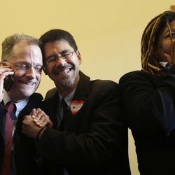 John Lewis, left, and his partner Stuart Gaffney embrace as they react next to Andrea Shorter after the Supreme Court decision at the office of San Francisco Mayor Ed Lee at City Hall in San Francisco, Wednesday, June 26, 2013.
