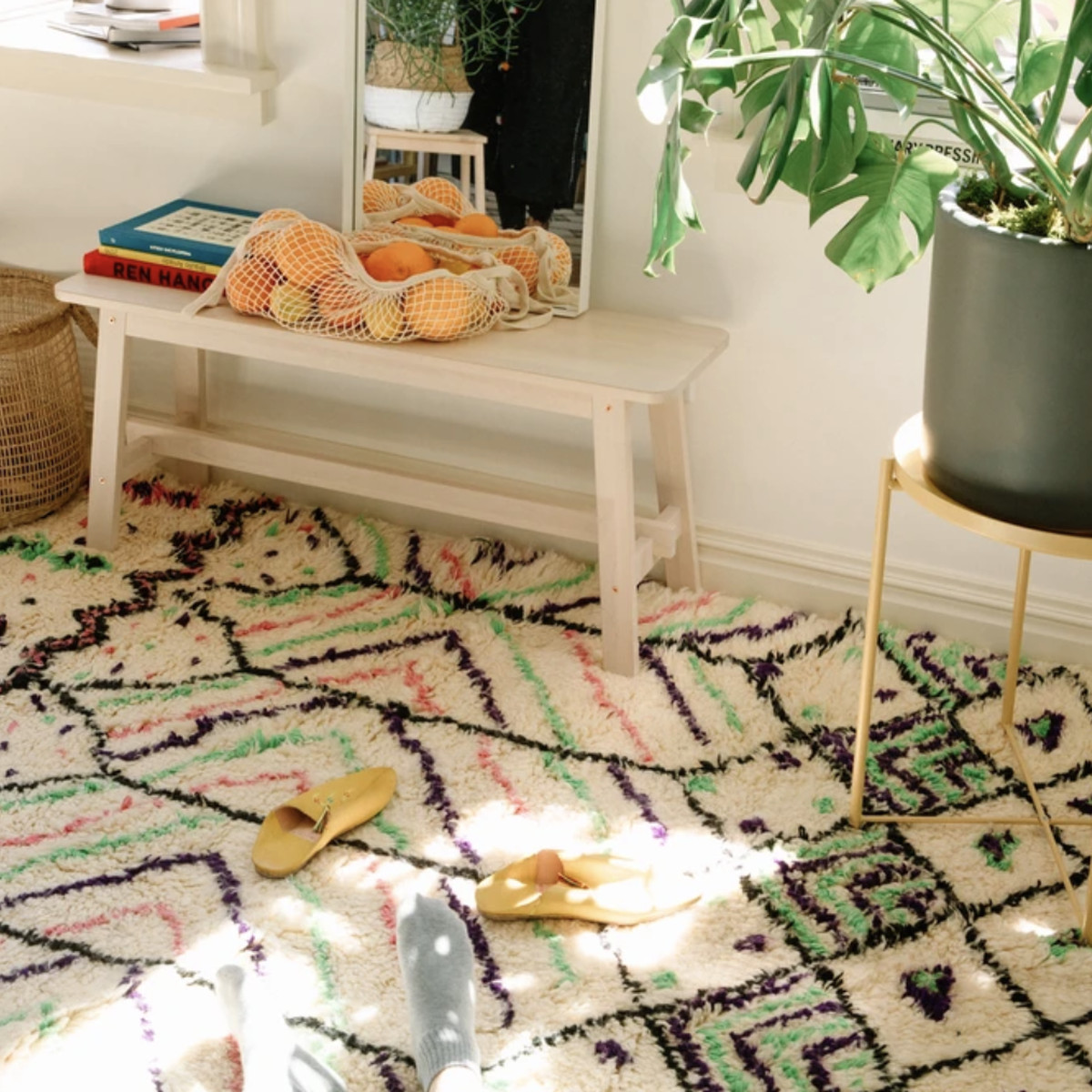 A white, black, pink, and green Moroccan rug