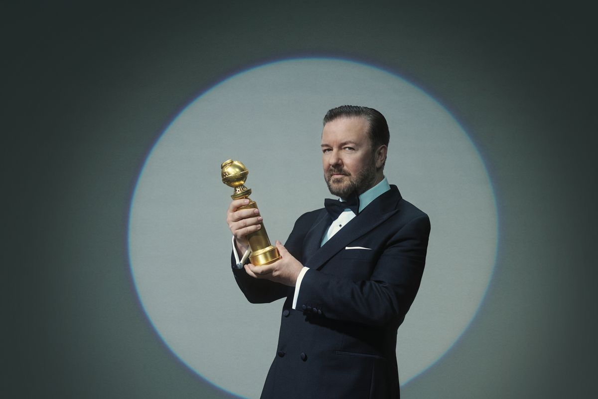 Host Ricky Gervais holding a Golden Globe Award statue.