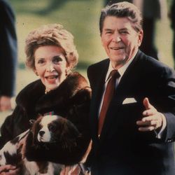 FILE - This December 1986, file photo shows first lady Nancy Reagan holding the Reagans' pet Rex, a King Charles spaniel, as she and President Reagan walk on the White House South lawn. The former first lady has died at 94, The Associated Press confirmed Sunday, March 6, 2016. 