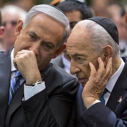 Israeli Prime Minister Benjamin Netanyahu, left, speaks with Israeli President Shimon Peres during the Remembrance Day ceremony in the Mount Herzl Military Cemetery in Jerusalem, Israel, Monday, April 15, 2013. The sad atmosphere ends sharply at sundown when in jarring contrast, Israelis joyfully take to the streets for independence day celebrations with dancing, fireworks and parties. 