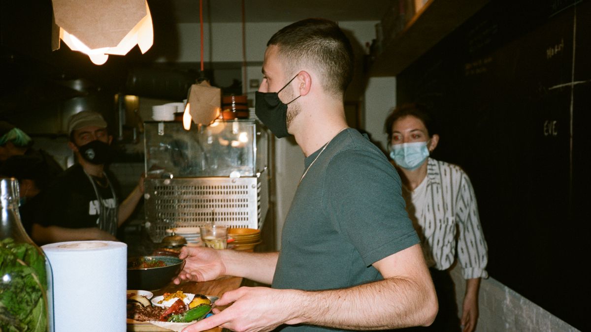 Wait staff prepare to run dishes to guests indoors at Nandine in Camberwell