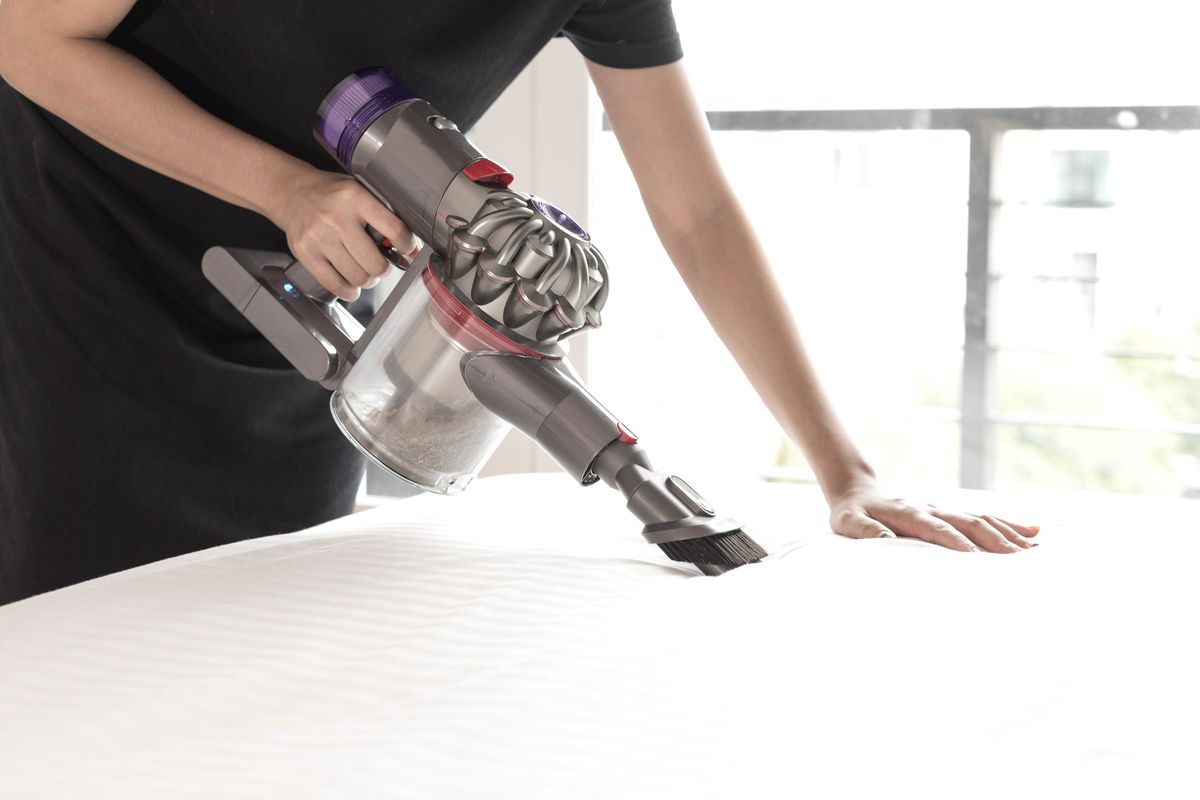 Vacuuming a mattress. 