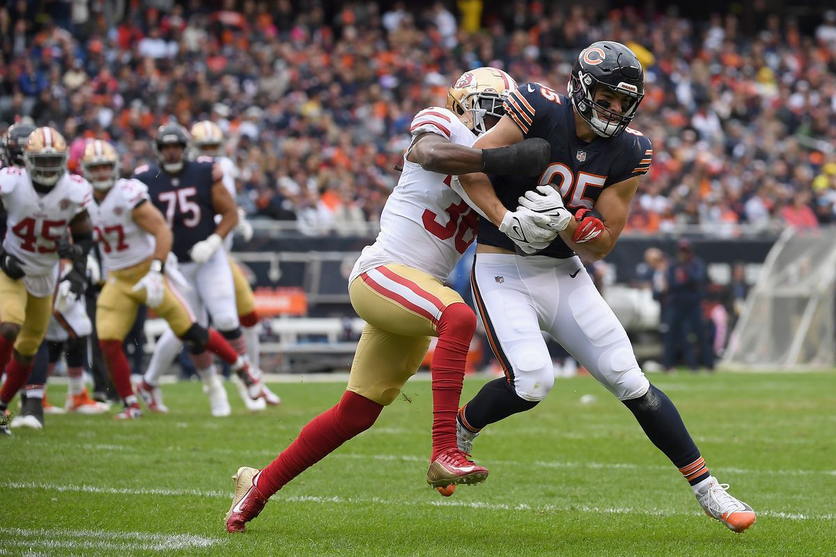 Cole Kmet #85 of the Chicago Bears runs with the ball while being chased by Marcell Harris #36 of the San Francisco 49ers in the second quarter at Soldier Field on October 31, 2021 in Chicago, Illinois.