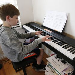 Isaac Nance, who has hemophilia – a rare bleeding disorder —plays the piano at his home in Draper on Thursday, March 24, 2016. 