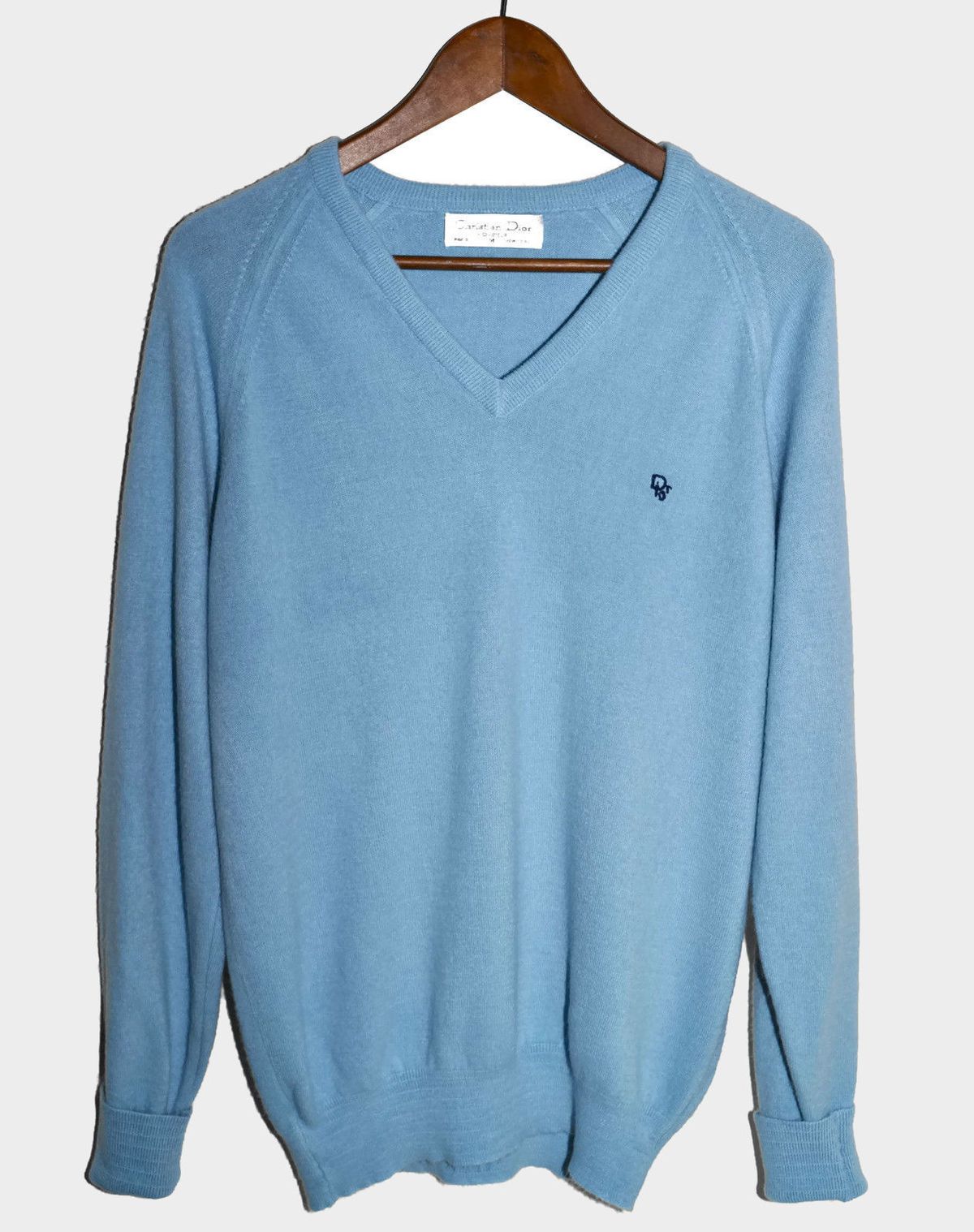 A baby blue Christian Dior men’s sweater on a hanger