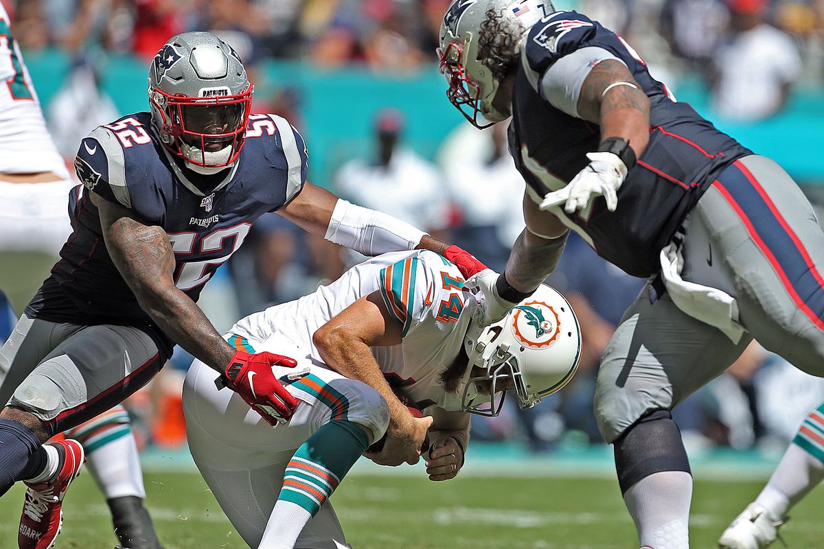 Elandon Roberts of the New England Patriots and Danny Shelton sacks Ryan Fitzpatrick of the Miami Dolphins during the third quarter of the NFL game at the Hard Rock Stadium on September 15, 2019 in Miami, Florida.