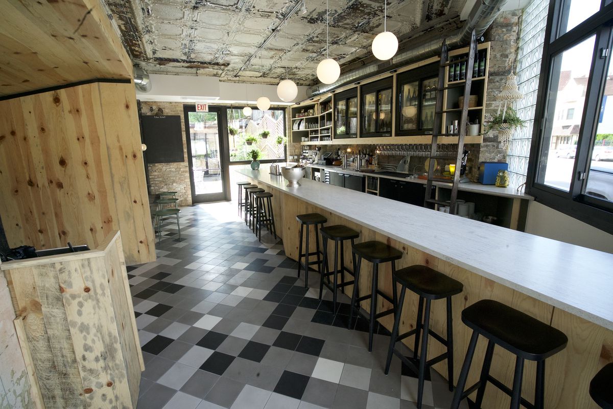 A bar’s interior with black and white tiled floors.