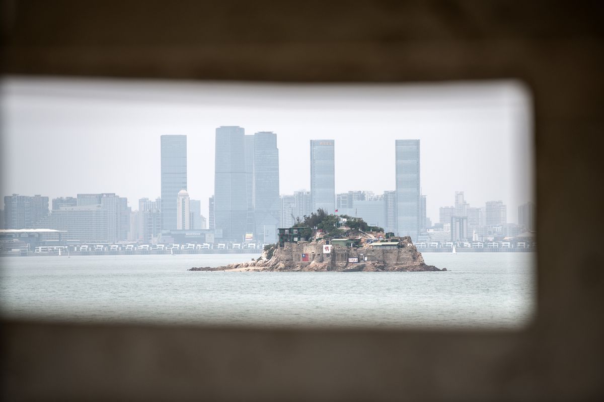 A tiny Taiwanese island is viewed through the hole of a gun emplacement in front of the Chinese city of Xiamen on April 20, 2018.