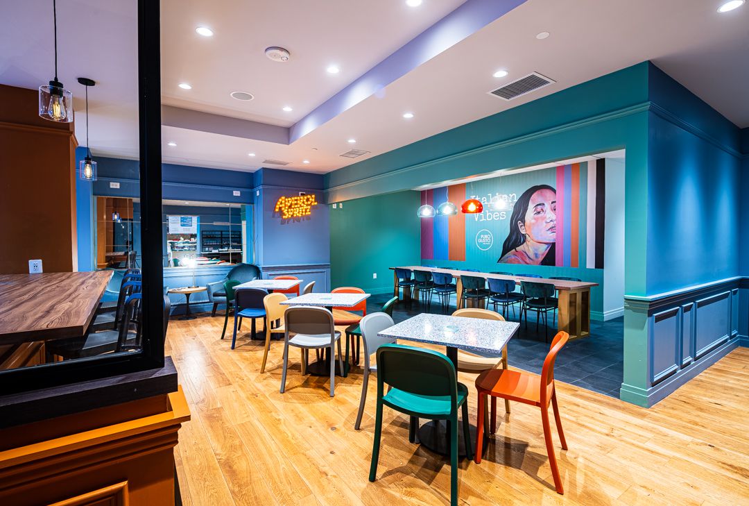the interior of puro gusto with colorful murals and chairs