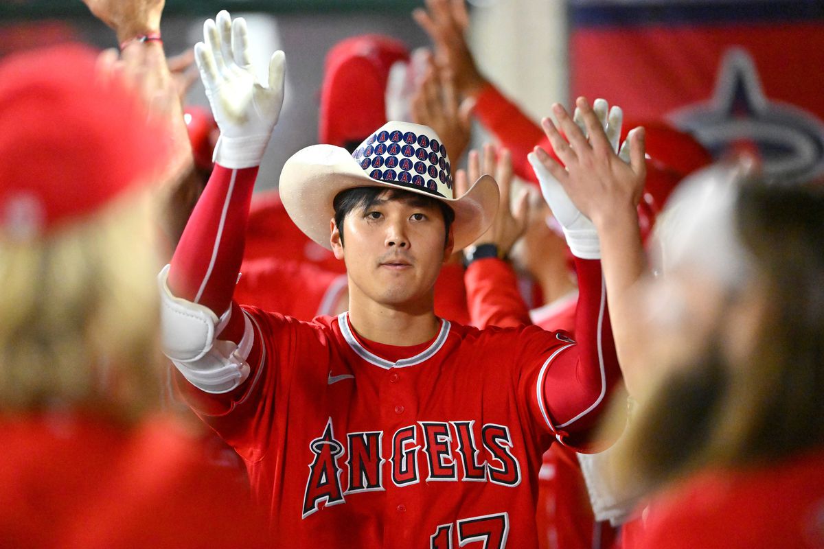 Shohei Ohtani #17 of the Los Angeles Angels is congratulated in the dugout after hitting a 3-run home run in the sixth inning of the game against the Kansas City Royals at Angel Stadium of Anaheim on June 21, 2022 in Anaheim, California.
